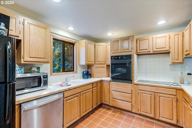 kitchen featuring light brown cabinets, light tile patterned floors, sink, black appliances, and decorative backsplash