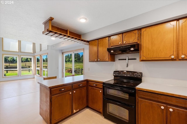 kitchen with kitchen peninsula, black electric range oven, and a textured ceiling