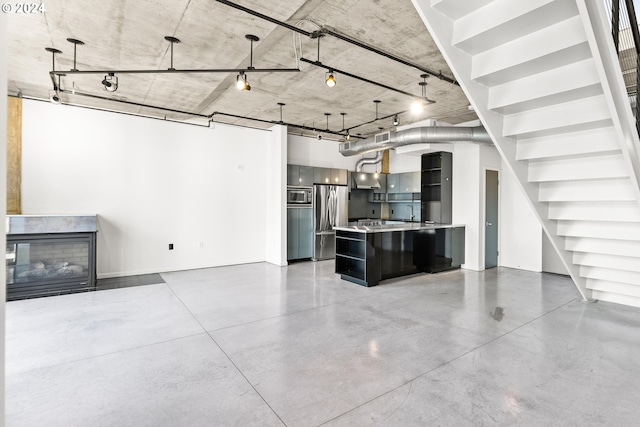 unfurnished living room with a glass covered fireplace, visible vents, and finished concrete flooring