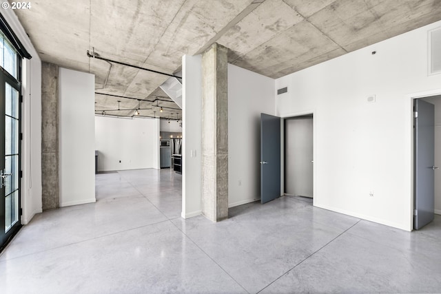 spare room featuring visible vents, baseboards, and finished concrete flooring