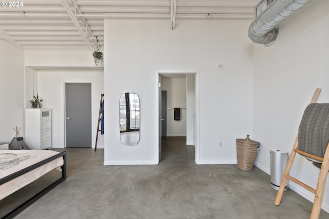 bedroom featuring concrete floors and baseboards