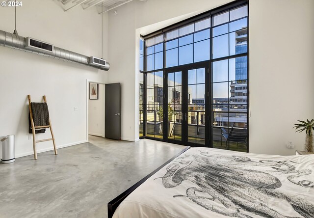 bedroom featuring a high ceiling and concrete flooring