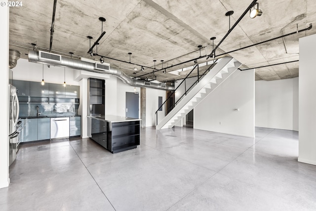 below grade area featuring a sink, stairway, visible vents, and stainless steel refrigerator