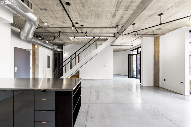 basement with baseboards and stairs