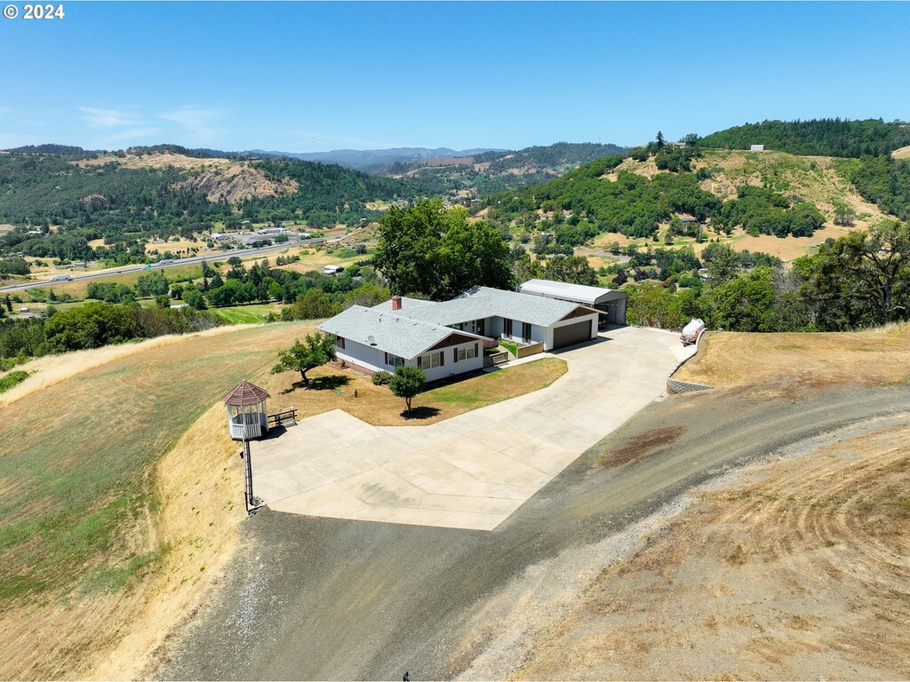 984 Wagontire Dr, Myrtle Creek, OR 97457 - aerial view of property and surrounding area featuring a mountainous background