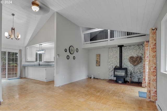 22715 SW Eagle Point Rd, Sheridan, OR 97378 - unfurnished living room featuring a chandelier, high vaulted ceiling, a baseboard radiator, a wood stove, and wooden ceiling