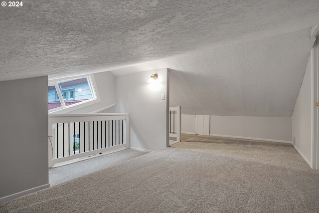 bonus room featuring carpet flooring, lofted ceiling, and a textured ceiling