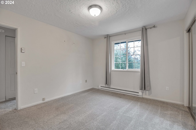 carpeted empty room with a textured ceiling and a baseboard radiator