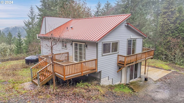 back of house with a patio area and a wooden deck