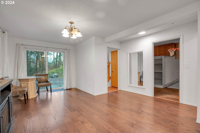 living room with hardwood / wood-style floors, a baseboard heating unit, a fireplace, and a chandelier