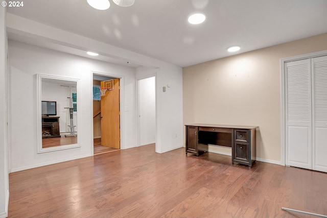 unfurnished room featuring a wall unit AC, a healthy amount of sunlight, a baseboard radiator, and dark hardwood / wood-style floors