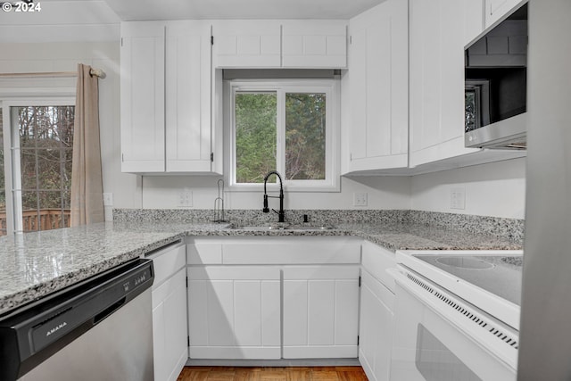 22715 SW Eagle Point Rd, Sheridan, OR 97378 - kitchen with stainless steel dishwasher, white electric range oven, a sink, white cabinets, and light stone countertops