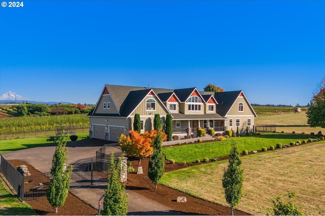 view of front of property with a mountain view, a rural view, a garage, and a front lawn