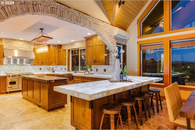 33138 SE Bluff Rd, Boring, OR 97009 - kitchen featuring wall chimney exhaust hood, a kitchen island, a wall unit AC, range with two ovens, and decorative backsplash