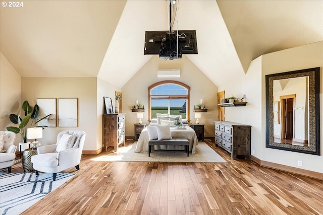 bedroom with a wall mounted AC and light hardwood / wood-style flooring