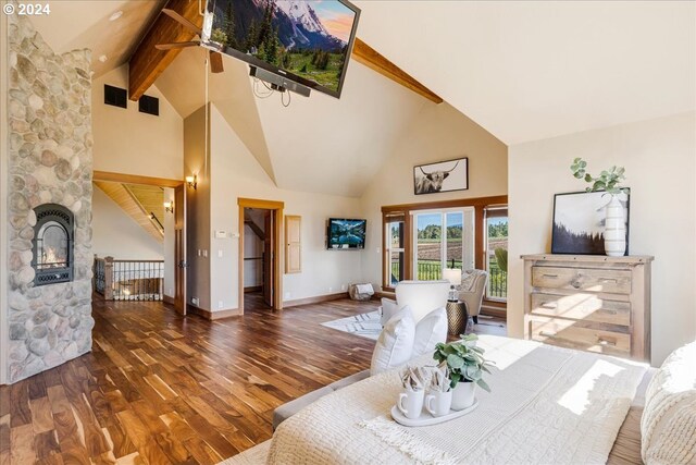 dining room featuring a stone fireplace, beamed ceiling, dark wood-type flooring, and high vaulted ceiling