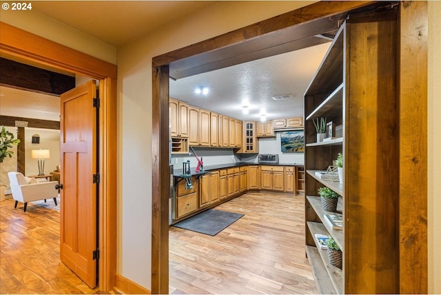 33138 SE Bluff Rd, Boring, OR 97009 - kitchen with open shelves, light wood-style flooring, dark countertops, and glass insert cabinets