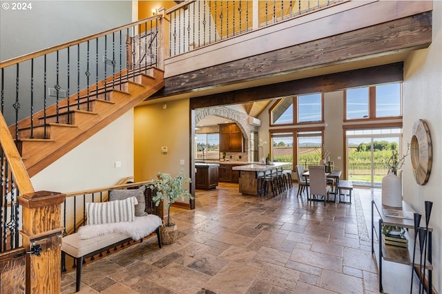 33138 SE Bluff Rd, Boring, OR 97009 - living room with stone tile flooring, a towering ceiling, arched walkways, and stairway