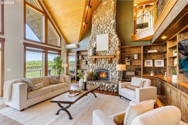 living room featuring high vaulted ceiling, a wall mounted AC, light hardwood / wood-style floors, a fireplace, and wood ceiling