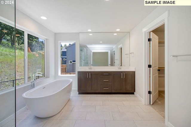 bathroom featuring vanity, tile patterned floors, and a bathtub