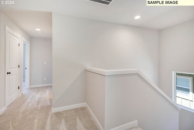 hallway featuring light colored carpet