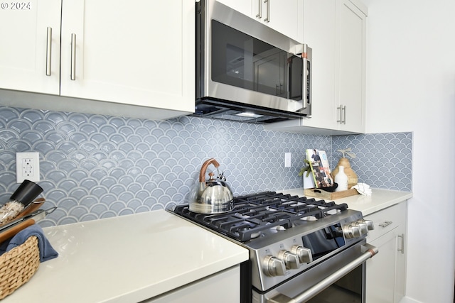 kitchen featuring tasteful backsplash, white cabinetry, and appliances with stainless steel finishes