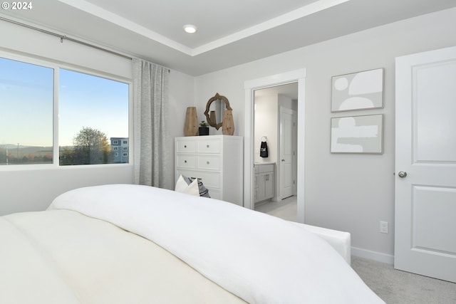 bedroom featuring light carpet and ensuite bath