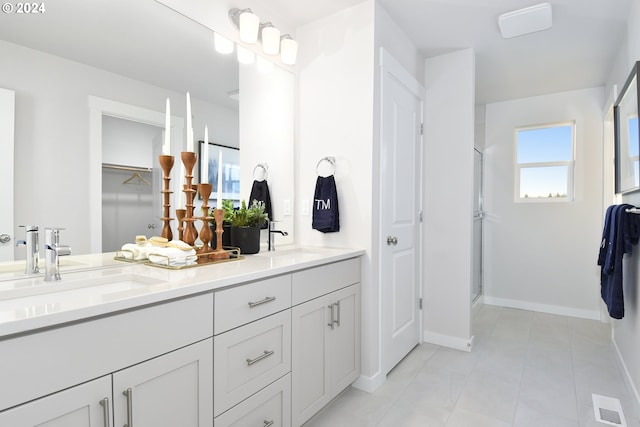 bathroom featuring tile patterned flooring, vanity, and a shower with door