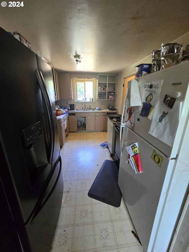 140 7th Ave, Sweet Home, OR 97386 - kitchen with refrigerator with ice dispenser, freestanding refrigerator, light flooring, range, and light countertops