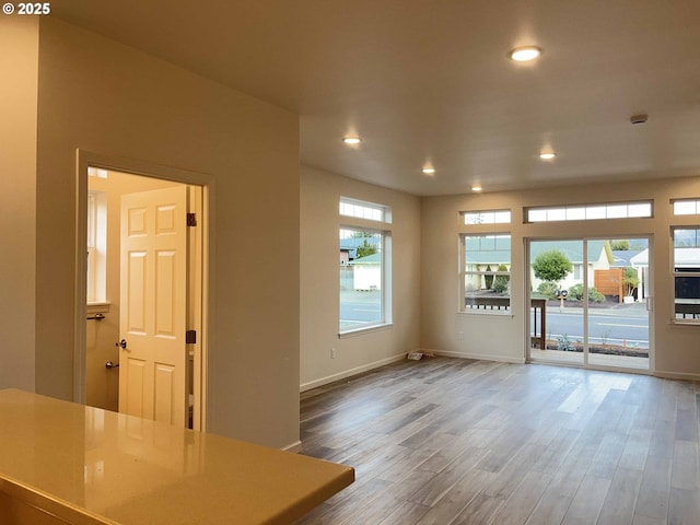 interior space with recessed lighting, wood finished floors, and baseboards