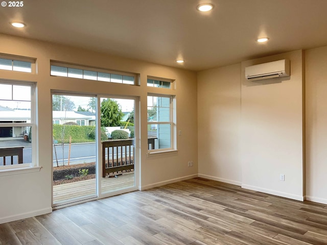 doorway with baseboards, a wall unit AC, wood finished floors, and recessed lighting