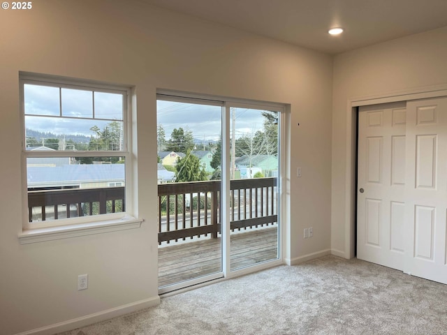 entryway featuring a wealth of natural light, baseboards, carpet floors, and recessed lighting