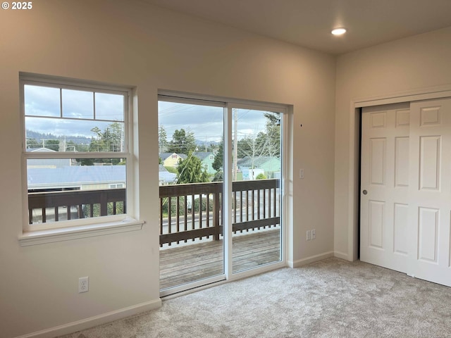 doorway to outside with a healthy amount of sunlight, carpet, baseboards, and recessed lighting