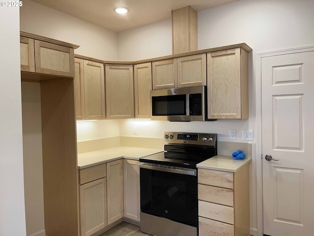 kitchen featuring stainless steel appliances, light brown cabinets, light countertops, and recessed lighting