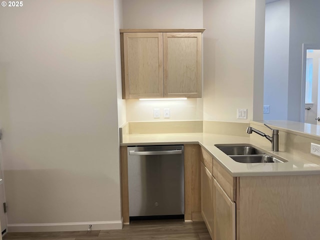 kitchen featuring stainless steel dishwasher, a sink, light brown cabinetry, light countertops, and dark wood-style flooring