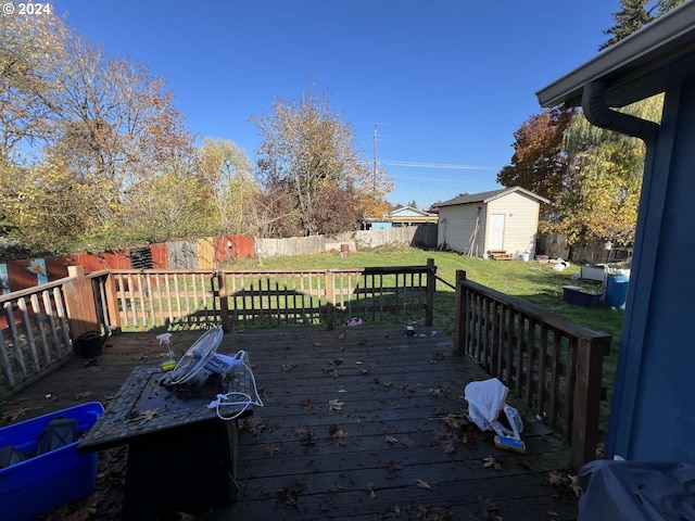 wooden deck with a storage unit and a lawn