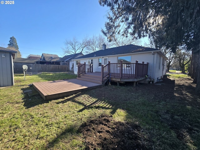 back of house with a deck and a lawn