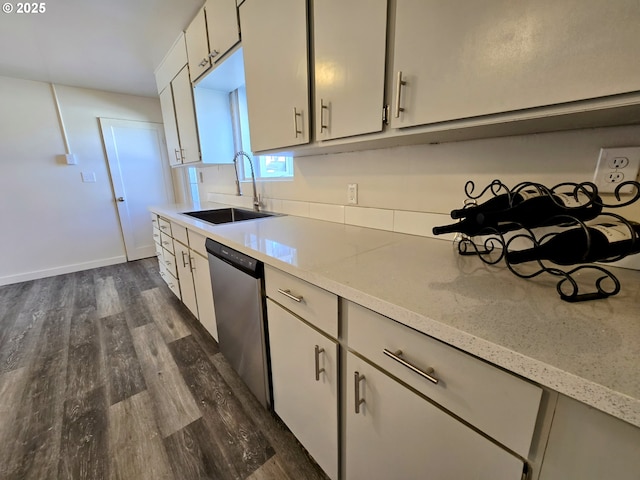 kitchen with dishwasher, light stone countertops, sink, and dark wood-type flooring