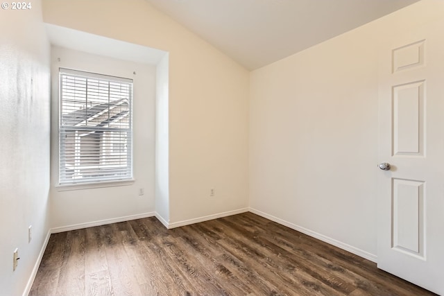 unfurnished room featuring lofted ceiling and dark hardwood / wood-style floors