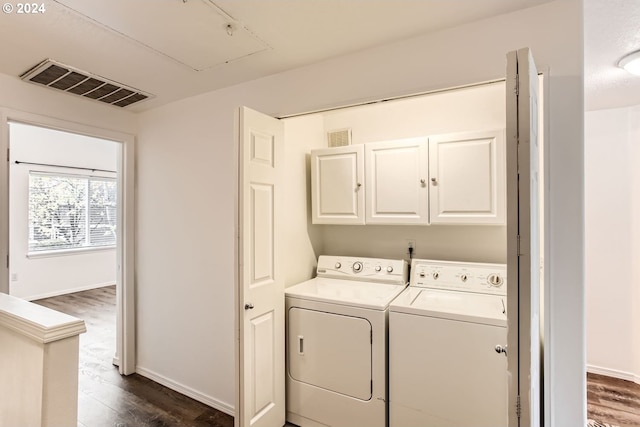 8686 NE Hyde Park Ln, Hillsboro, OR 97006 - clothes washing area with visible vents, dark wood-style flooring, washing machine and dryer, attic access, and cabinet space