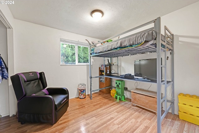 bedroom featuring wood-type flooring and a textured ceiling