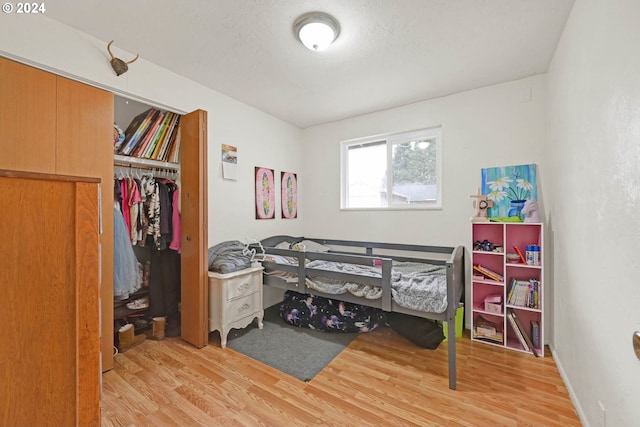 bedroom featuring light hardwood / wood-style floors, a closet, and a textured ceiling