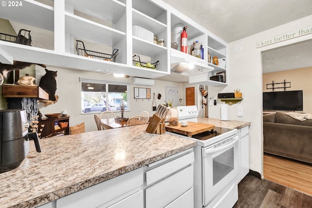 kitchen featuring built in shelves, white cabinetry, a wall mounted air conditioner, dark hardwood / wood-style floors, and electric stove