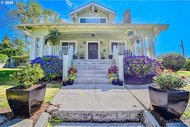 view of front of home featuring a porch and a chimney