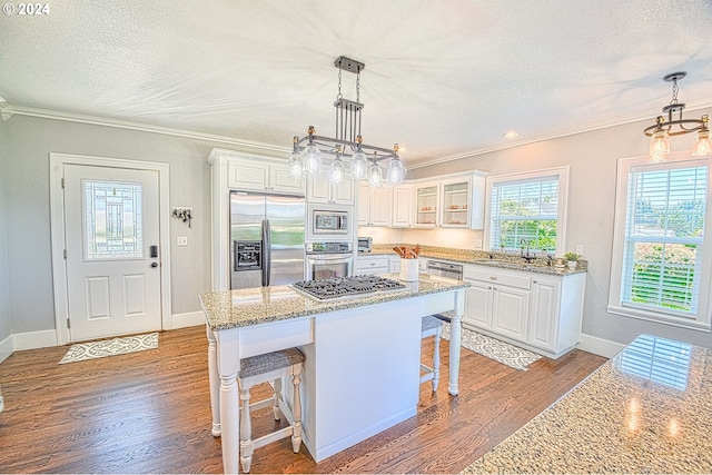 kitchen with a center island, light hardwood / wood-style flooring, stainless steel appliances, and white cabinets