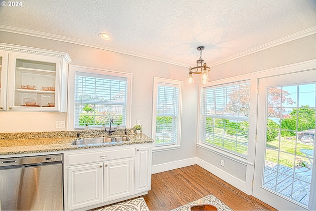 kitchen with pendant lighting, ornamental molding, light hardwood / wood-style flooring, stainless steel dishwasher, and white cabinets