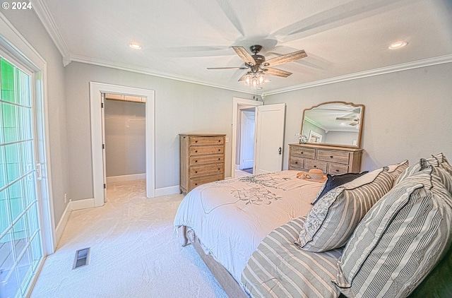 bedroom featuring crown molding, light colored carpet, ceiling fan, and a walk in closet