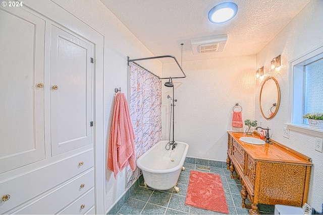 bathroom with tile patterned flooring, a textured ceiling, and vanity