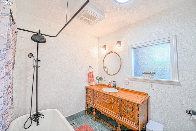 bathroom with shower / bathtub combination with curtain, tile patterned flooring, vanity, and a textured ceiling