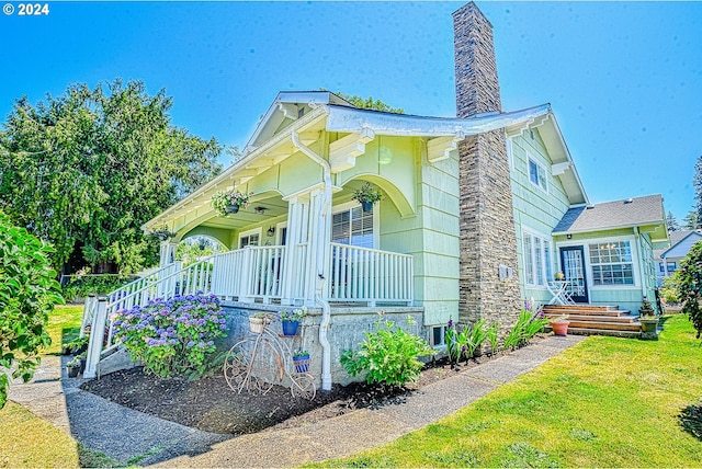 view of front of house featuring covered porch and a front lawn